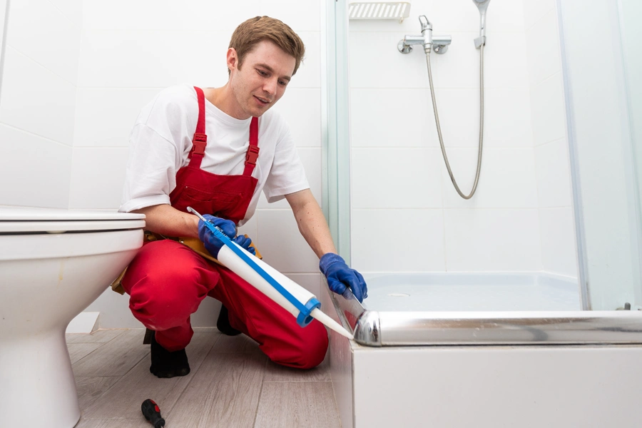 low-income-assistance-man-caulking-shower